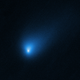 A bright comet, 2I/Borisov, lefts a bright blue cometary trail as it passes through space.
